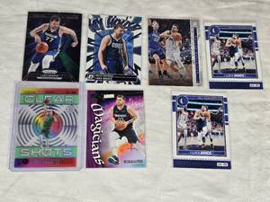Lot of 7 Luka Doncic Basketball Cards including Panini Prizm, Optic, and Donruss, featuring special inserts like Clear Shots and Magicians.