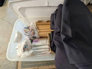 Bin of scrapbookalbum sheets, tape and supplies