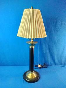 Vintage table lamp featuring a brass and black column with a pleated shade.