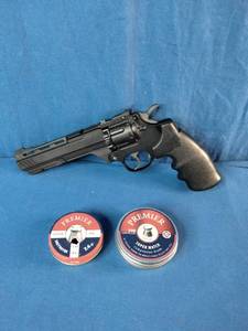 Crosman Vigilante CO2 revolver air pistol accompanied by two tins of .177 caliber Premier pellets.