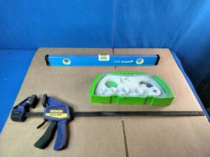 Empire True Blue level, a Milwaukee hole saw kit, and an Irwin Quick-Grip clamp.