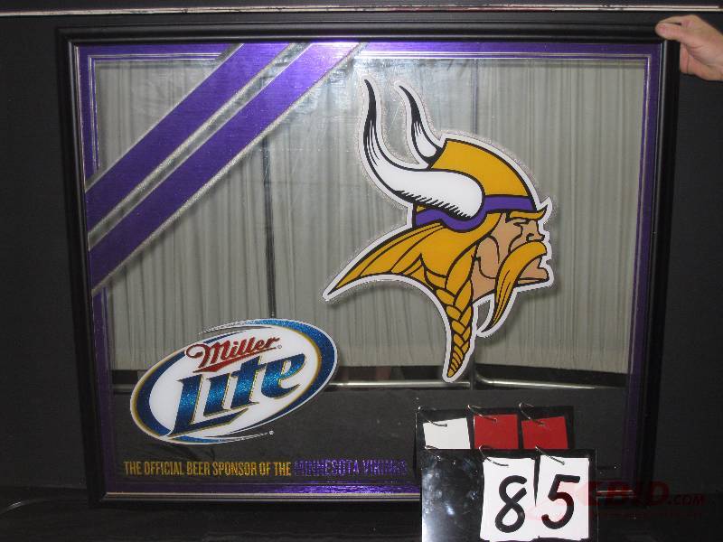 lot 85 image: Miller Lite MN Vikings logo mirror - New in Box (NIB). (white curtain in background reflection of mirror not part of graphics) 39 w x 33 h