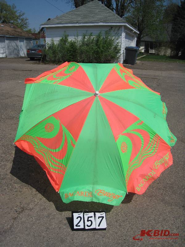 lot 257 image: Barcardi Breezer beach umbrella PinkGreen, pointed end to insert in ground 60 diam.