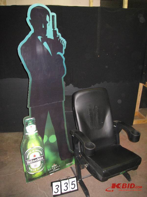 lot 335 image: Heineken 007 Skyfall movie premiere, branded theater-style seat arms lift up and down with drink holders, heavy duty frame, embossed back rest, comes with lifesize James Bond cardboard cutout