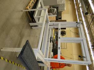 Steel frame, adjustable height workbench with laminate top and wired with electrical outlets 120V plugs