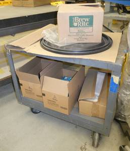 rolling steel cart full of caribou coffee and filters and a box of trash bags