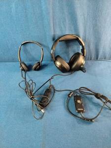 Two distinct wired headsets resting on a blue textured fabric background.