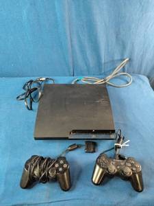 Sony PlayStation 3 Slim console bundle, which includes two black wireless controllers, a power cord, and a video cable
