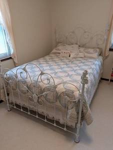 Scrolled Metal Bed Frame With Patchwork Quilt
