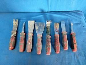 Mac Tools scrappers and tools, which often have distinctive red and black ergonomic handles.