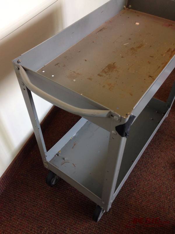 lot 140 image: Metal pushcart on wheels. Measures 16in wide,...