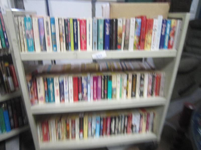 3 SHELVES OF PAPERBACK BOOKS.