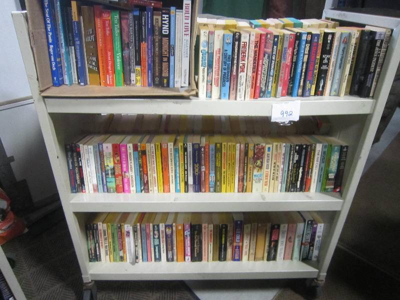 3 SHELVES FULL OF PAPER BACK BOOKS.
