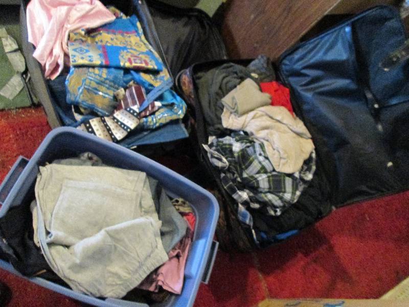 2 suitcases and a plastic bin fille...