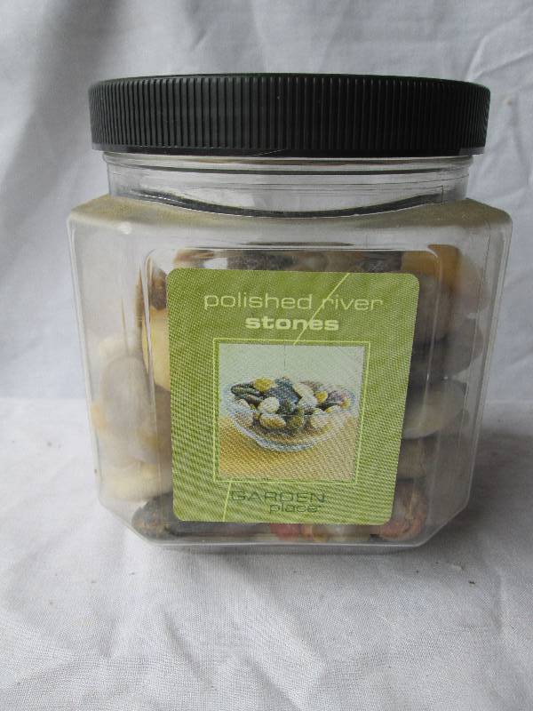 Jar of polished river stones for de...