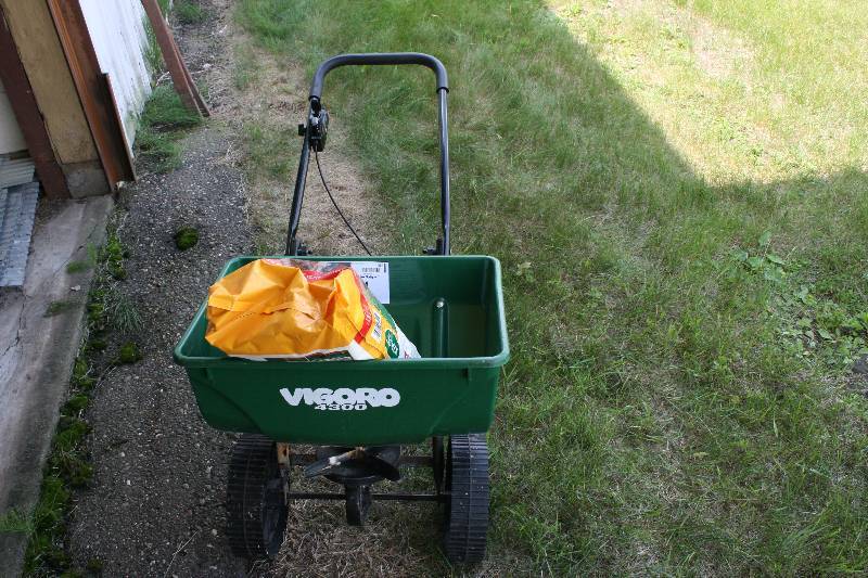 lot 254 image: Seed Spreader wHandle & Spreading Bucket Includes Scotts Winterizer Turf Builder.