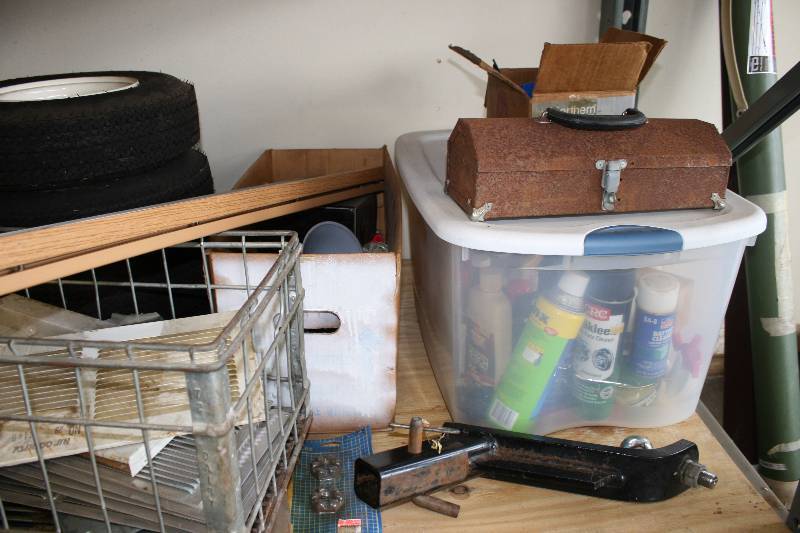 lot 233 image: Shelving Lot Including Tiki Torch Wheels Metal Basket And More Shelving Unit Not Included.