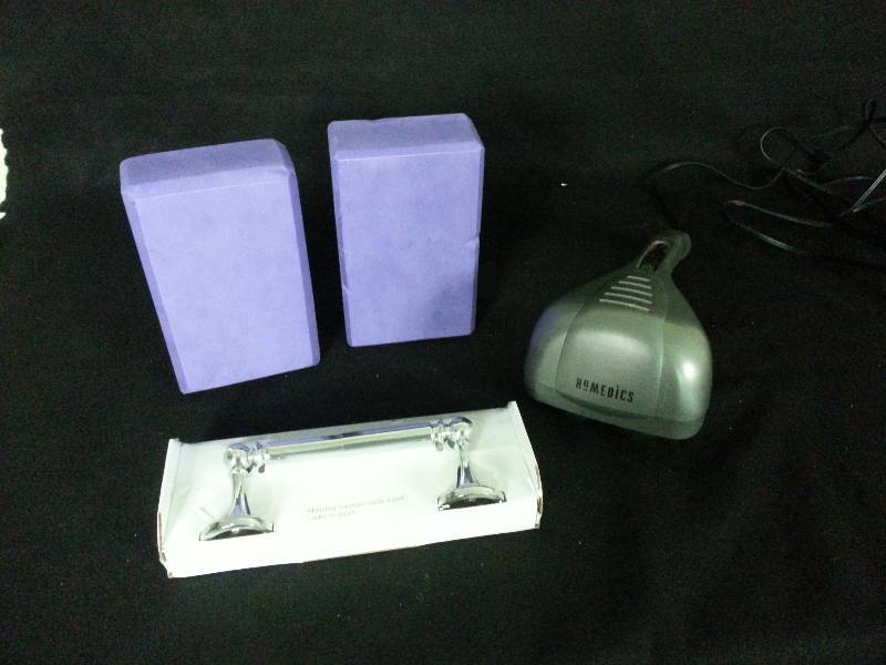 lot 93 image: Homedics Massager, Toilete Paper Hardware, and Two Foam Bricks