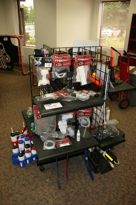 lot 1070 image: Contents of Metal Display Including Metal Display Unit C.H.A. Goalie Mask Harness Player Helmet Repair Kits And More 36 x 36 x 53.