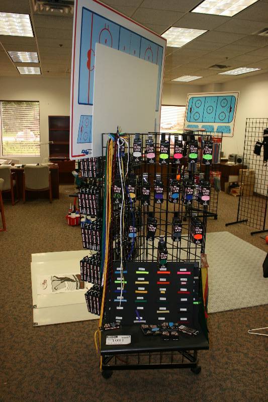 lot 1081 image: Contents of Metal dIsplay Rack Including C.H.A. Ultra Lace Packages, Miscellaneous Colors DG Tools Hockey Playmaker Dry-Erase Board And More.