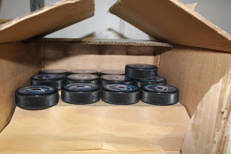 lot 825 image: Box Lot of Hockey Pucks wColorado Avalanche Logo.
