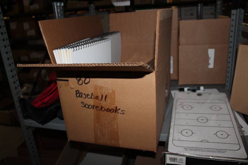lot 863 image: Shelf Lot Including Hockey Play Maker Dry Erase Boards Baseball Scorebooks, 18 Space Detailed BaseballSoftball Scorebooks, Bound, app. 70 ct.