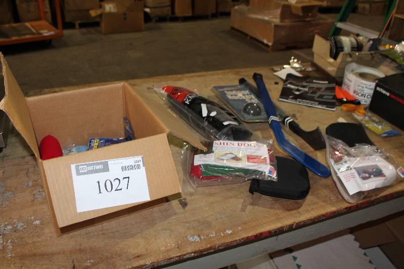 lot 1027 image: Table Lot Including Shin Dogs Shin Protectors Plastic Hockey Sticks BaseballSoftball Knee Pad And More.