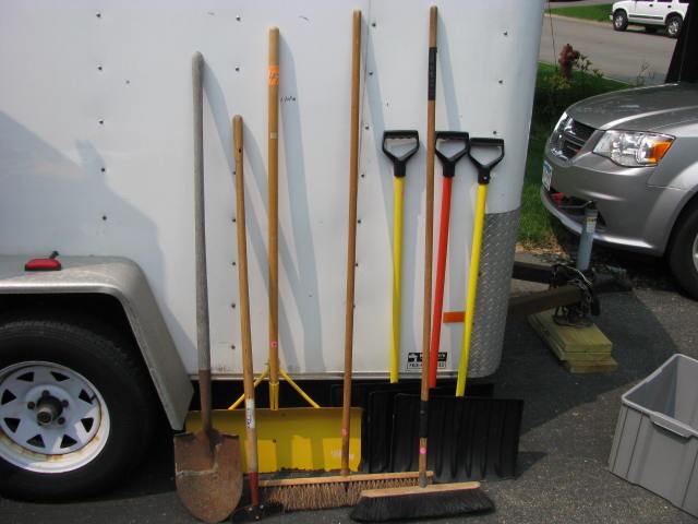 lot of snow shovels, shop brooms and more