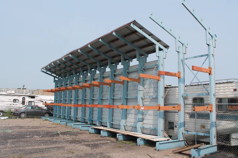 lot 10 image: Cantilever Material Racking Unit with (14) Uprights and (28) Load Arms with Metal Awning and Backing Included.