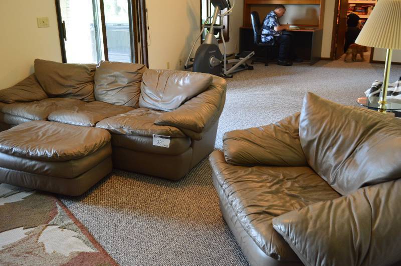 lot 33 image: Taupe Colored Leather Couch Overstuffed Chair & Ottomoan Couch 9) x 44 x 27 Chair 56 x 42 x 30 Ottoman 35 x 23 x 15.