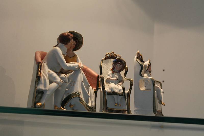 lot 95 image: Shelf Lot Including Figurines In Chairs Kissing Couple Figurines.