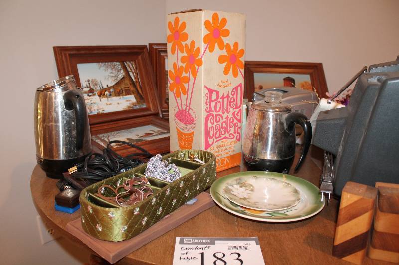 lot 183 image: Contents of Table Including Framed Pictures Potted Coasters Plates And More.