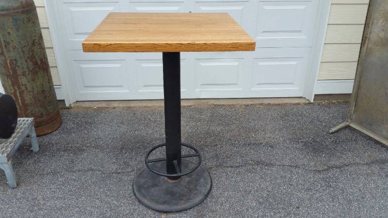 lot 28 image: 2, 24IN X 24IN Solid Oak  restaurant tables.. Metal base with foot rest