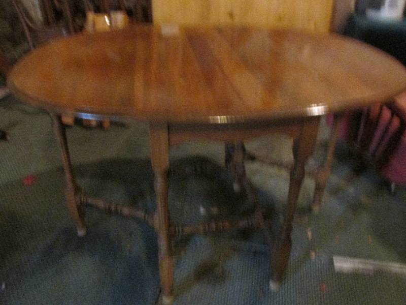Oval wood table with drop leaves on...