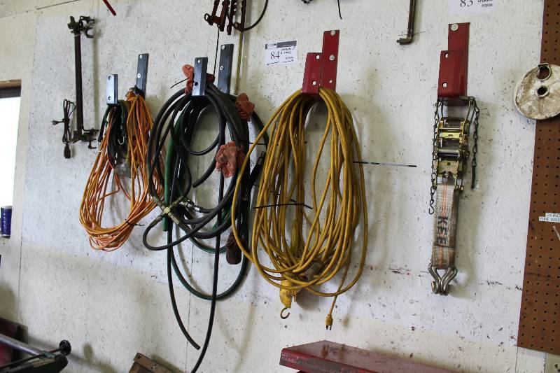 lot 84 image: Contents of (4) Hooks Including Extension Cords Hoses wAttachments Heavy-Duty Ratchet Strap And More.