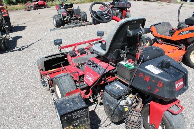 lot 24 image: Toro Greensmaster 3100 Commercial Riding Lawn Mower wSteering Wheel & Seat Front Flood Lights Protective Blade Guards Kohler Engines Motor M16S Tested & Operational But Has Bad Battery Battery Starter Not Included.