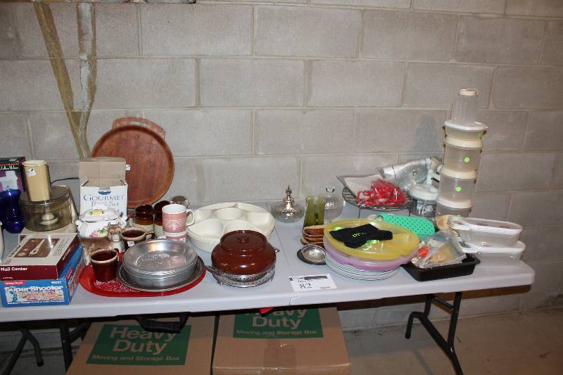 lot 82 image: Table Lot Including Metal Dishes Plastic Plates Plastic Storage Containers And More.