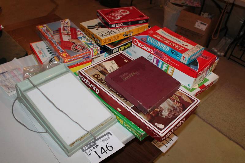 lot 146 image: Half Table Lot Including Wood Burning Tool Board Games Including Life, Monopoly, Checkers, And More.