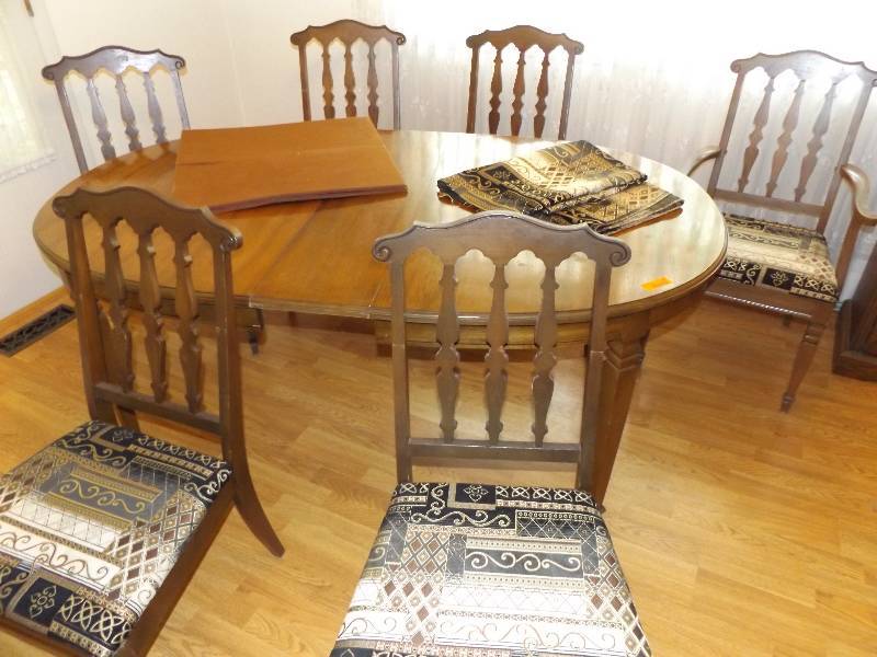 Dining room table with 1 leaf, 6 chairs, cover and extra material.