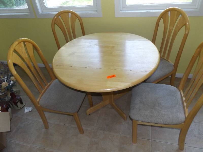 Blonde colored drop leaf table with 4 chairs.