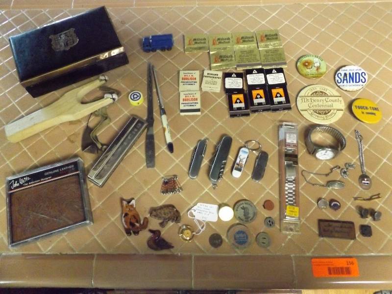 Matchbooks, pocket knives, harmonica, transit tokens, pins.