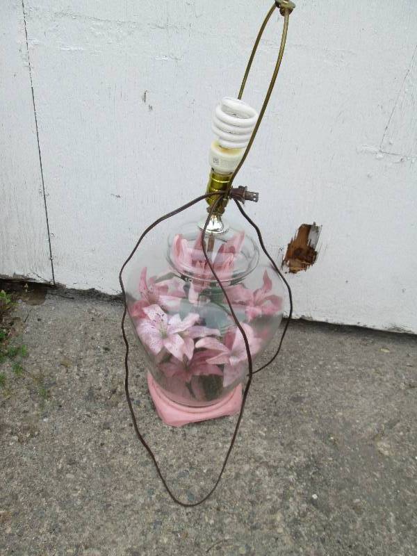 lamp with clear base and flowers in...
