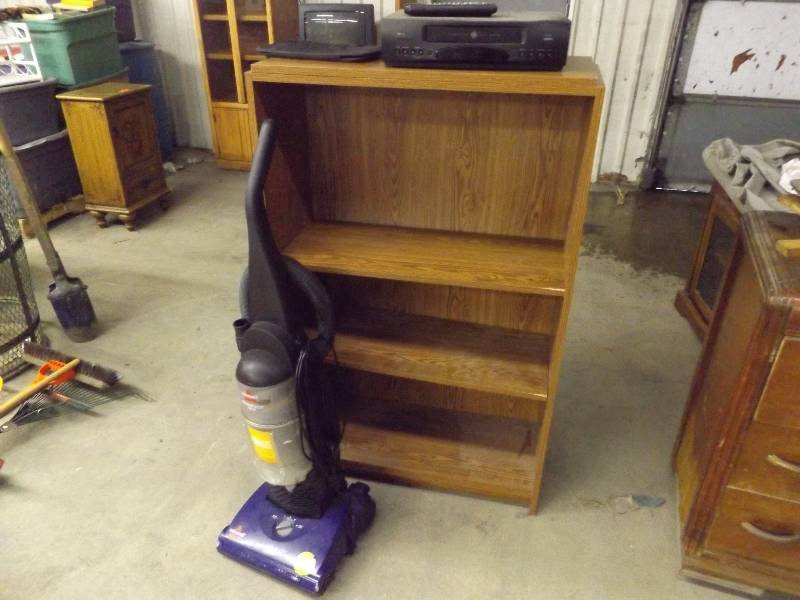 lot 116 image: 4 Shelf Pressed Wood Bookcase, GE VCR Player with Remote, CD holder, Bissell Vacuum