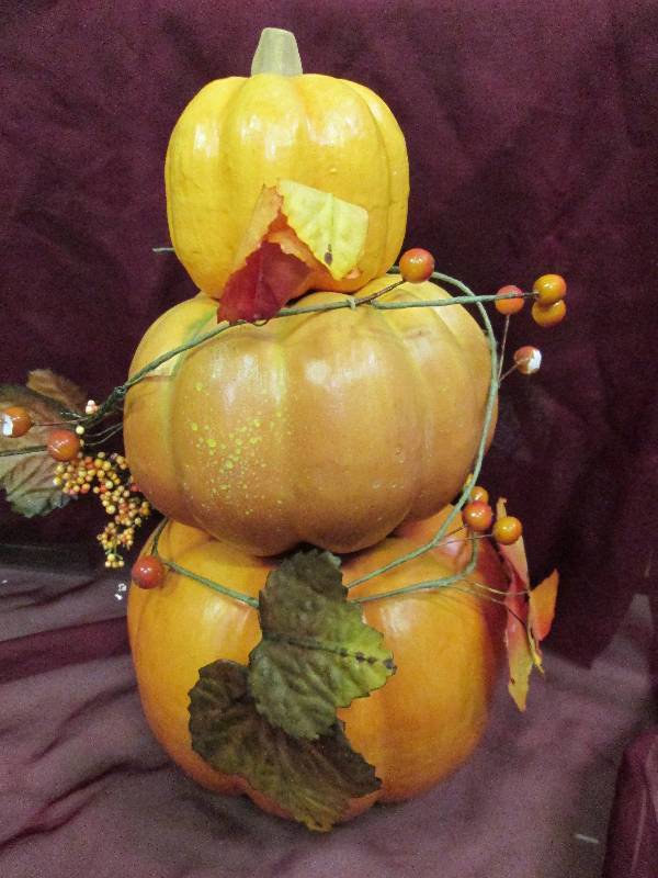 3 stacked pumpkins with fall greene...