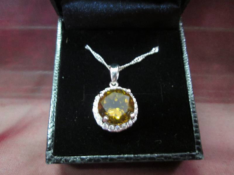 Amber color stone with crystals nec...