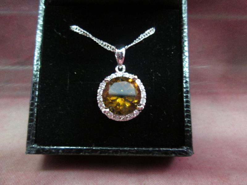 Amber color stone with crystals nec...