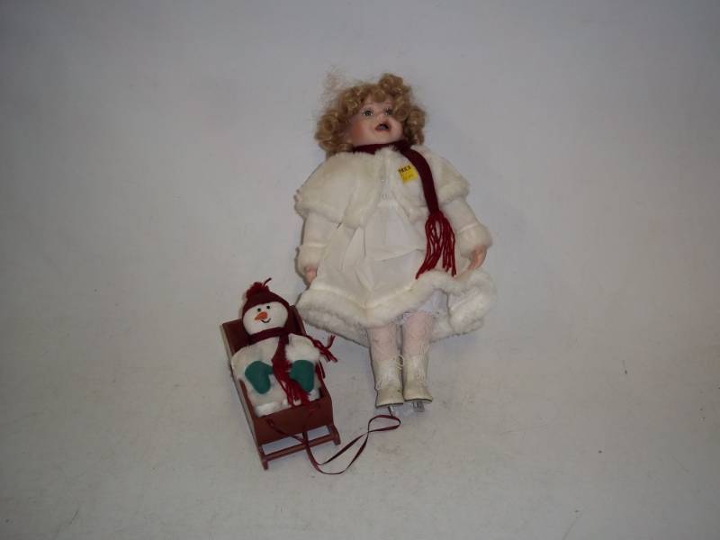 lot 239 image: 16 in Porcelain Doll with skates including sled and Snowman