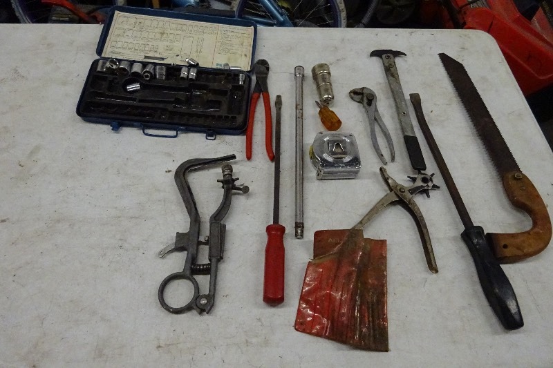 Saw, crow bar, battery post cleaner, screwdriver, side cutters, tape measure, and more