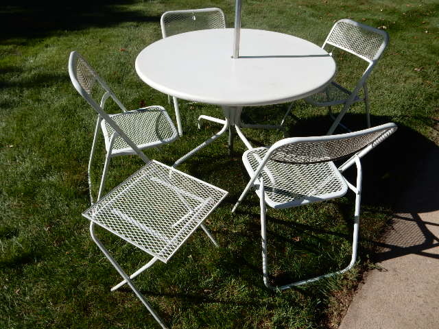 lot 282 image: White Metal Round table and 4 mesh metal folding chairs, small side table.. Umbrella.