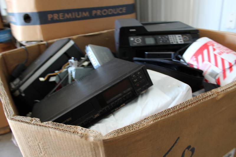 lot 18 image: Gaylord Box Lot of Used Electronics Including VHS Player, Multi-Function Printer, Bucket Of Miscellaneous Hardware, And More 466lbs Total Weight.
